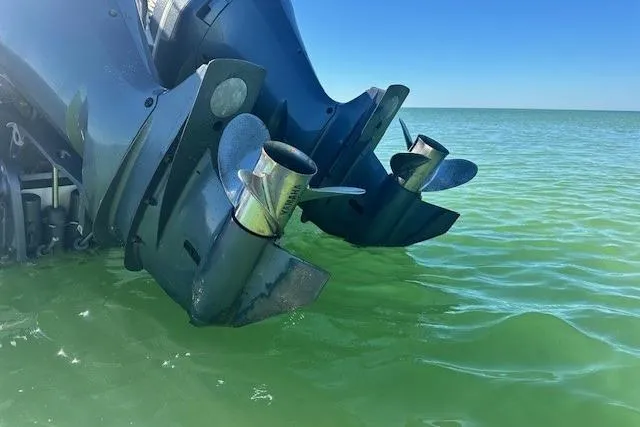 Slide: The Image of Twin outboard motors on a 2015 Edgewater 320CC in clear green water. - 4