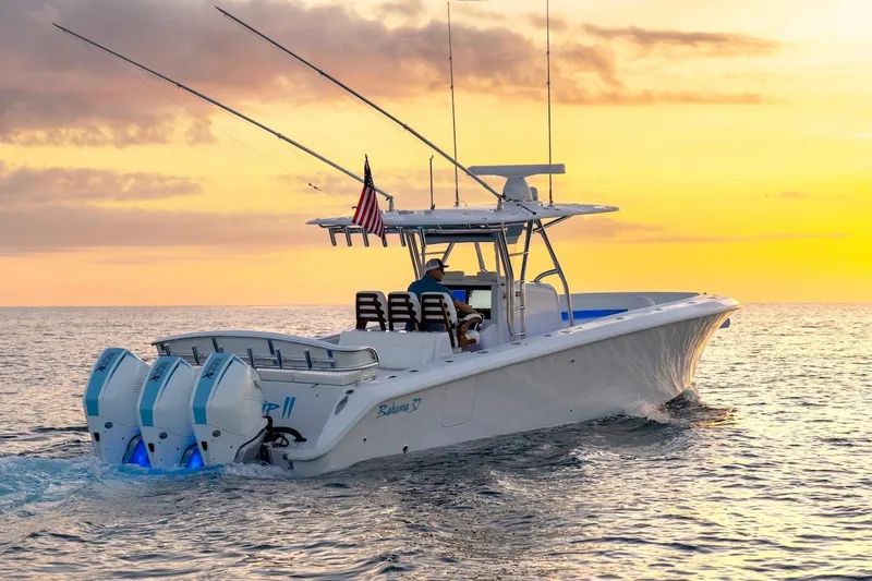 The Image of 2026 Bahama 37 Center Console boat cruising at sunset with triple engines. - 0