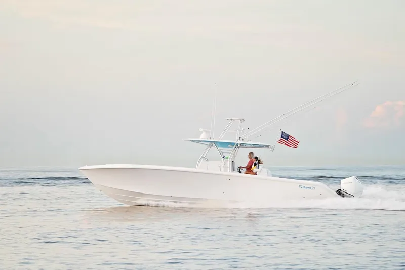 Slide: The Image of 2026 Bahama 37 Center Console boat cruising on calm waters with American flag. - 7