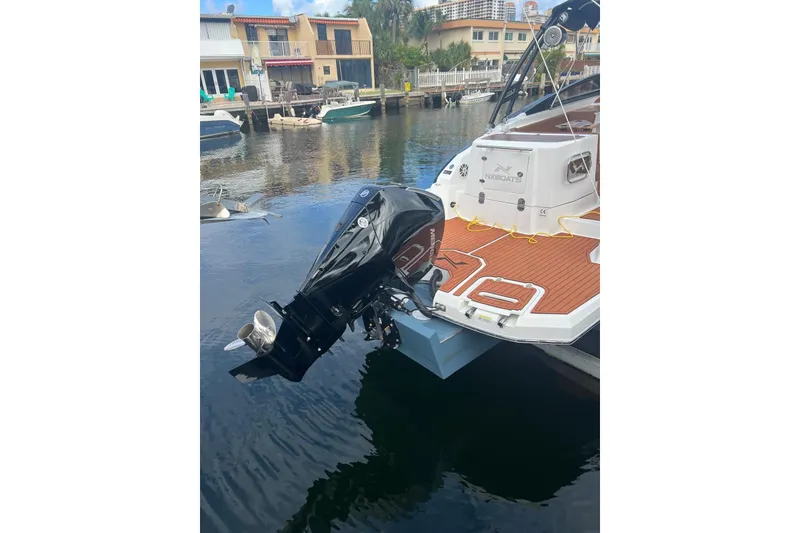 Slide: The Image of 2024 NX Boats NX270 with outboard motor docked in a canal. - 11