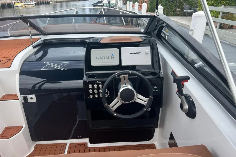 Slide: The Image of 2024 NX Boats NX270 dashboard with Garmin and Mercury displays, sleek steering wheel, and modern controls. - 4