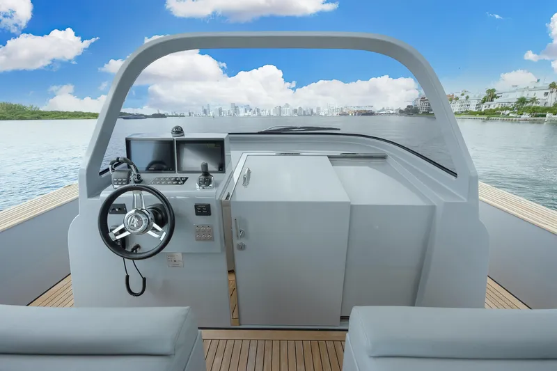 Slide: The Image of 2021 Alen 55 yacht cockpit with modern controls, steering wheel, and scenic water view. - 17