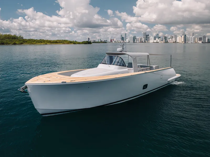 Slide: The Image of 2021 Alen 55 yacht cruising on calm waters with city skyline in background. - 4
