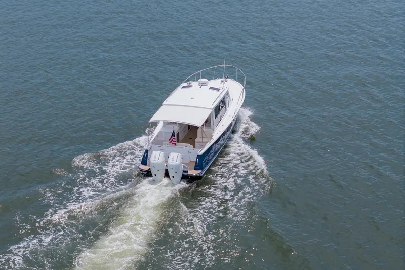 Slide: The Image of 2025 MJM 35 boat cruising on open water, rear view. - 13