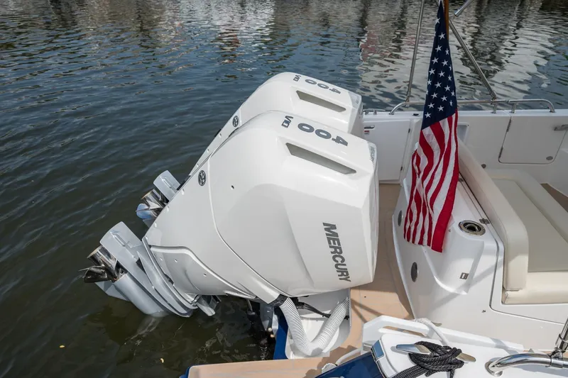 Slide: The Image of 2025 MJM 35 boat with dual Mercury 400 engines and American flag on water. - 14