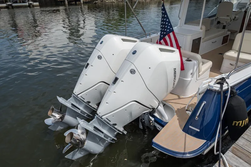 Slide: The Image of 2025 MJM 35 boat with dual Mercury outboard engines and American flag on water. - 15