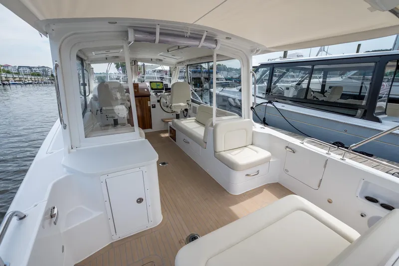 Slide: The Image of 2025 MJM 35 boat interior with seating, helm, and docked at marina. - 18