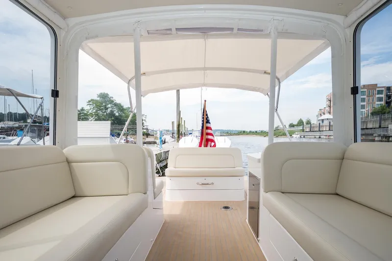 Slide: The Image of 2025 MJM 35 boat interior with beige seating and American flag. - 27