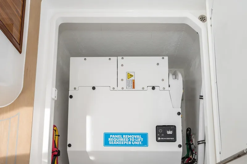 Slide: The Image of Seakeeper unit in 2025 MJM 35 boat, enclosed compartment with panel removal instructions. - 38