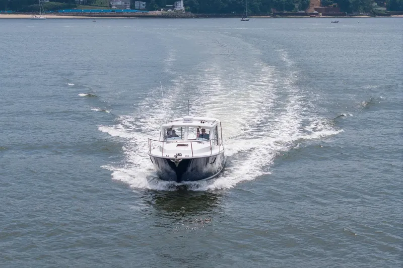 Slide: The Image of 2025 MJM 35 boat cruising on open water, leaving a wake behind. - 7