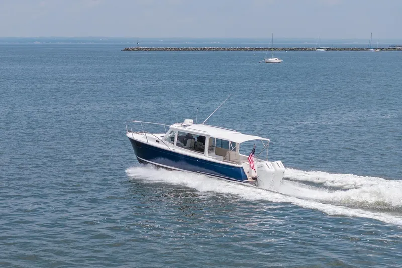 Slide: The Image of 2025 MJM 35 boat cruising on open water with American flag. - 9
