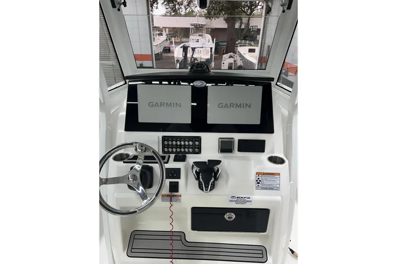 Slide: The Image of 2024 Sea Fox 288 Commander helm with dual Garmin displays and steering wheel. - 2