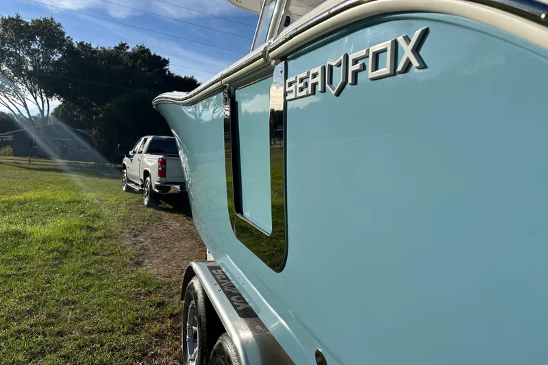 Slide: The Image of 2024 Sea Fox 288 Commander boat on trailer, parked beside a white truck. - 6