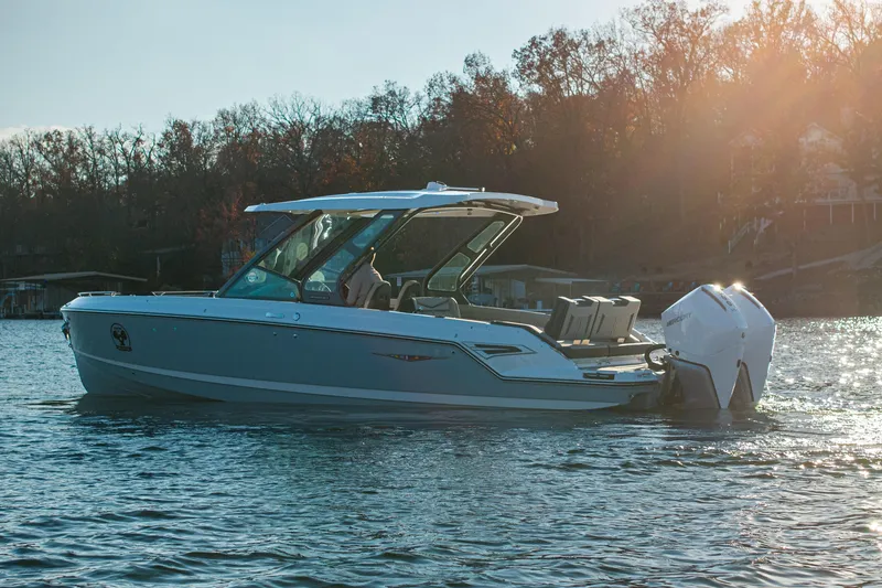 Slide: The Image of 2026 Monterey Elite 30 OB boat on a serene lake at sunset. - 12
