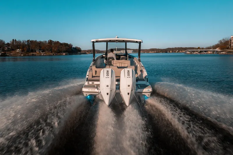 Slide: The Image of 2026 Monterey Elite 30 OB boat cruising on a serene lake under a clear blue sky. - 13