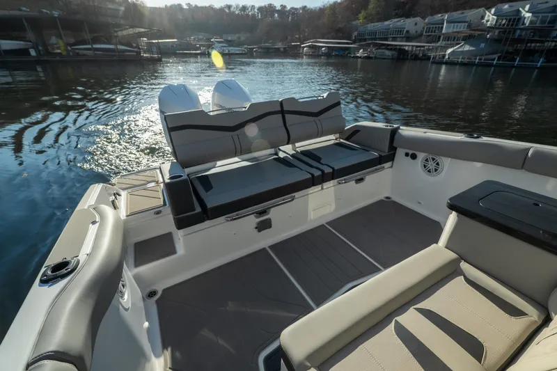 Slide: The Image of 2026 Monterey Elite 30 OB boat interior with seating, docked on a sunny day. - 19