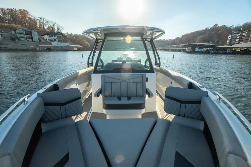 Slide: The Image of 2026 Monterey Elite 30 OB boat interior on a serene lake at sunset. - 29