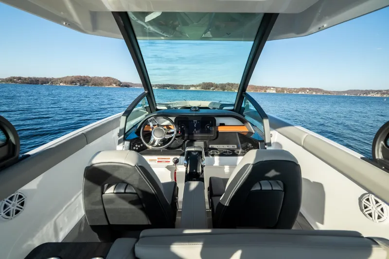 Slide: The Image of Interior view of 2026 Monterey Elite 30 OB boat cockpit on a serene lake. - 34