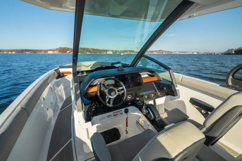 Slide: The Image of 2026 Monterey Elite 30 OB boat interior with modern dashboard on a serene lake. - 40
