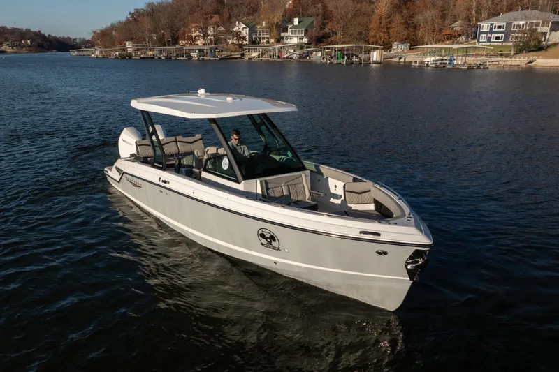 Slide: The Image of 2026 Monterey Elite 30 OB boat cruising on a serene lake with scenic shoreline. - 5