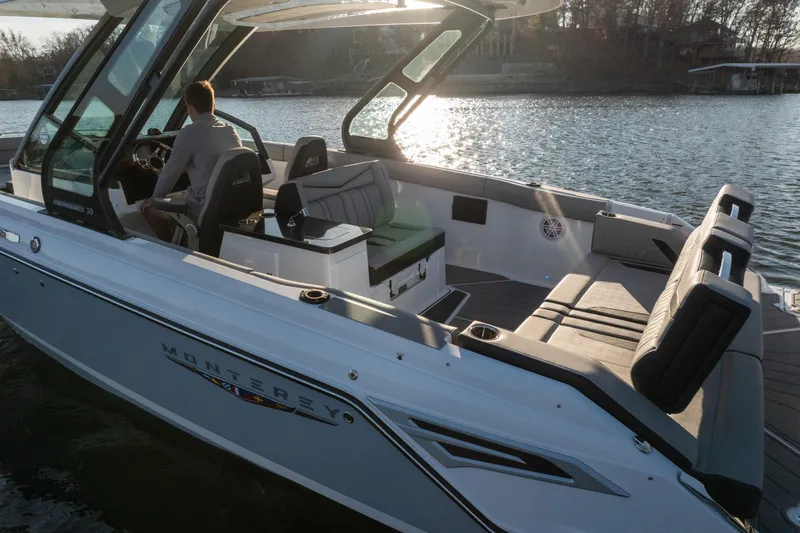 Slide: The Image of 2026 Monterey Elite 30 OB boat on a serene lake at sunset. - 6