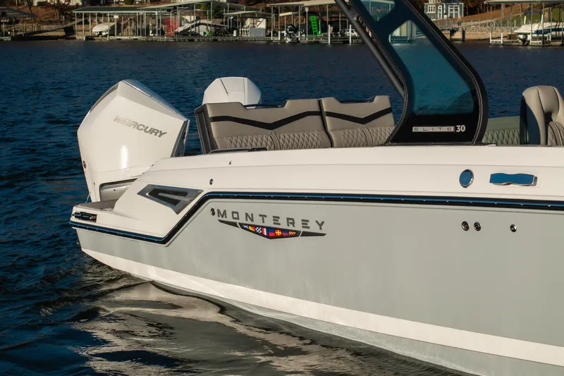 Slide: The Image of 2026 Monterey Elite 30 OB boat on water, featuring sleek design and Mercury engine. - 9