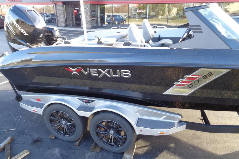 Slide: The Image of 2022 Vexus DVX22 boat on trailer, featuring sleek design and Mercury engine. - 21