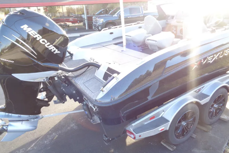 Slide: The Image of 2022 Vexus DVX22 boat with Mercury Verado engine on a trailer, sunlit view. - 22