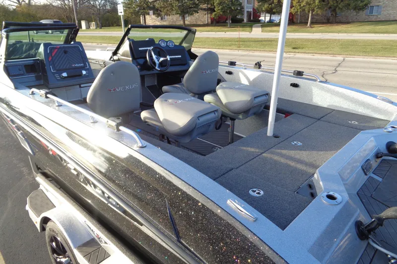 Slide: The Image of 2022 Vexus DVX22 boat interior with seating and dashboard, parked on a street. - 23