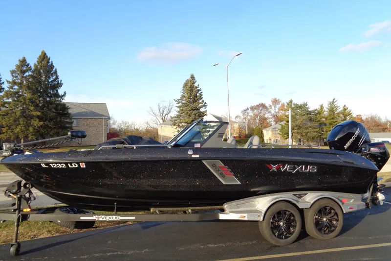 Slide: The Image of 2022 Vexus DVX22 boat on trailer, black exterior, parked outdoors. - 24