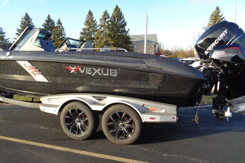 Slide: The Image of 2022 Vexus DVX22 boat with Mercury motor on a trailer, parked outdoors. - 25