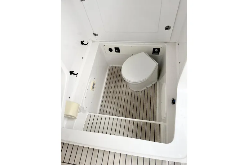 Slide: The Image of 2013 Midnight Express 39S Open boat bathroom with wooden flooring and compact toilet. - 8