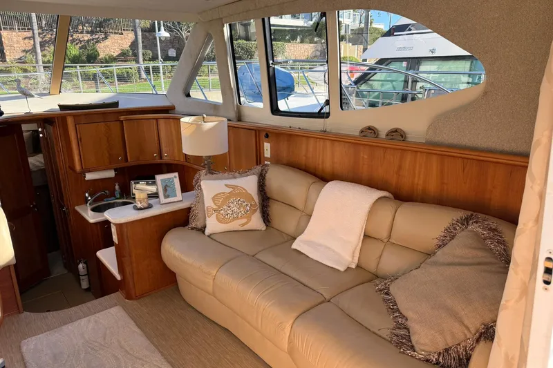 Slide: The Image of Interior of 2003 Silverton 38 Convertible yacht with beige leather sofa and wooden cabinetry. - 11