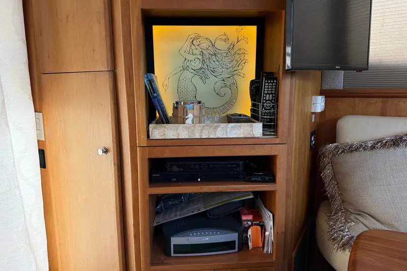 Slide: The Image of Interior of 2003 Silverton 38 Convertible with wooden shelves and decorative mermaid artwork. - 13