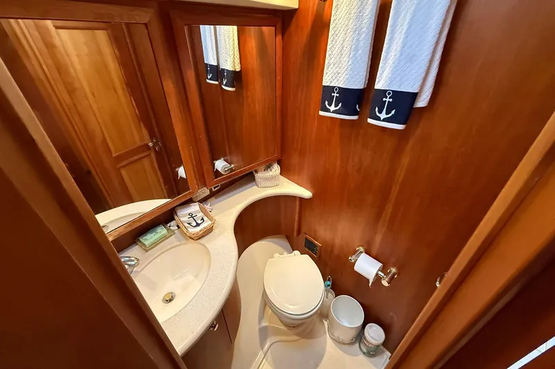 Slide: The Image of 2003 Silverton 38 Convertible yacht bathroom with wooden decor and nautical-themed towels. - 23