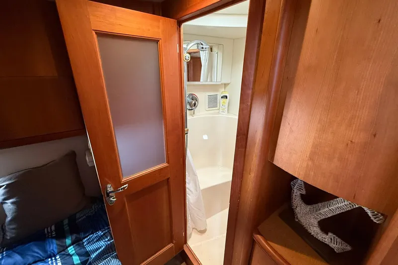 Slide: The Image of 2003 Silverton 38 Convertible yacht interior with wooden door and compact bathroom. - 24