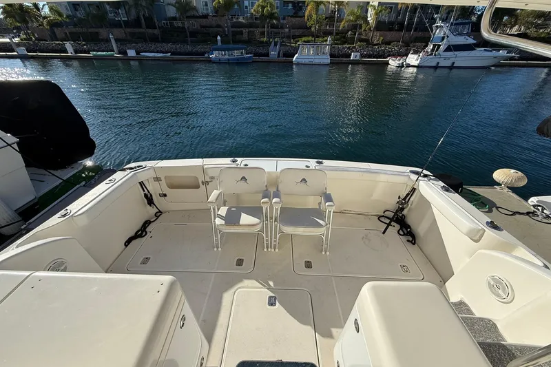 Slide: The Image of 2003 Silverton 38 Convertible boat deck with chairs, docked by calm waters. - 30