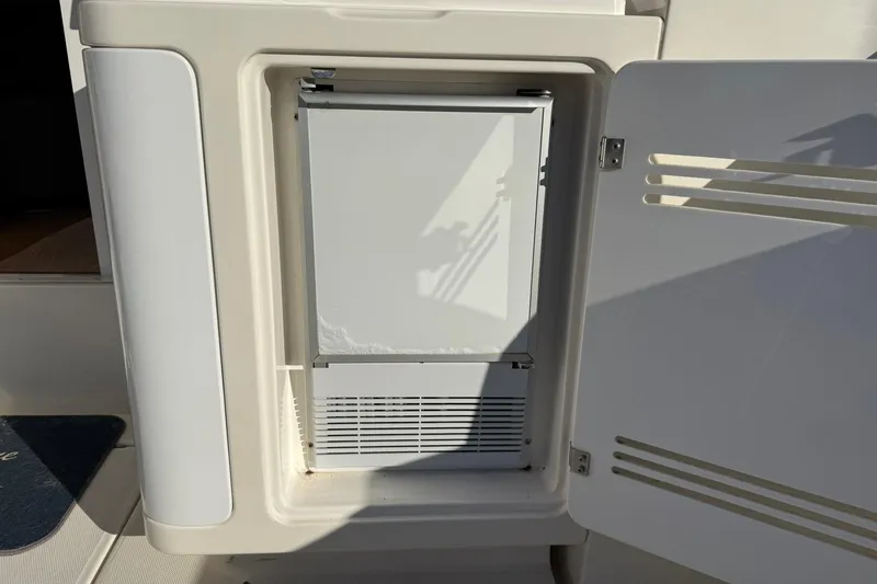 Slide: The Image of 2003 Silverton 38 Convertible boat refrigerator with open door, showcasing interior. - 32