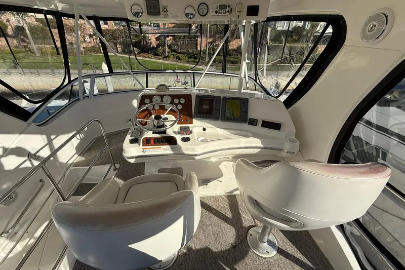 Slide: The Image of 2003 Silverton 38 Convertible yacht helm with modern controls and panoramic windows. - 39