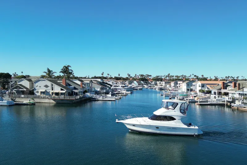 Slide: The Image of 2003 Silverton 38 Convertible yacht cruising in a scenic residential marina. - 5