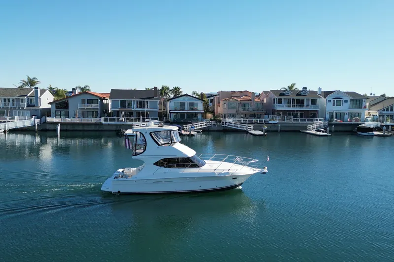 Slide: The Image of 2003 Silverton 38 Convertible yacht cruising near waterfront homes. - 6