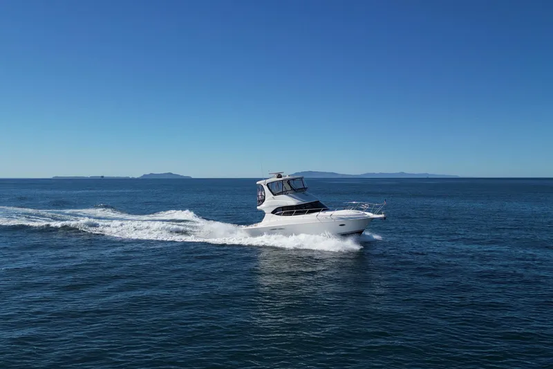 Slide: The Image of 2003 Silverton 38 Convertible yacht cruising on open sea under clear blue sky. - 8
