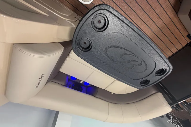 Slide: The Image of 2026 Bentley Pontoons Elite 223 Swingback interior with beige seating and black table. - 21