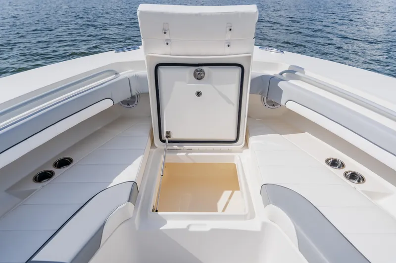 Slide: The Image of 2018 Regulator 41 boat interior with open storage compartment, white seating, and ocean backdrop. - 118