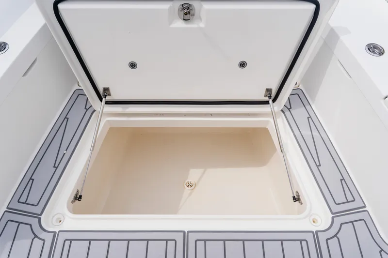 Slide: The Image of Open storage compartment on 2018 Regulator 41 boat with gray deck flooring. - 121