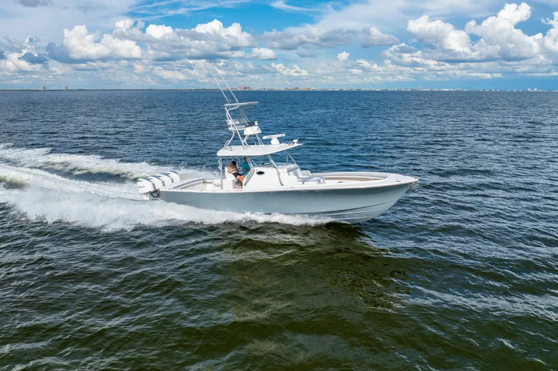 Slide: The Image of 2018 Regulator 41 boat cruising on open water under a partly cloudy sky. - 18