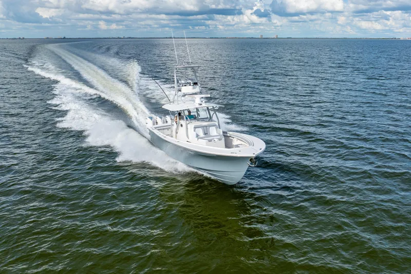 Slide: The Image of 2018 Regulator 41 boat cruising on open water under a partly cloudy sky. - 19