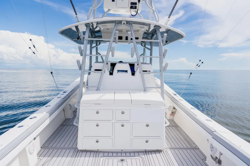 Slide: The Image of 2018 Regulator 41 boat interior with fishing equipment, calm ocean backdrop. - 46