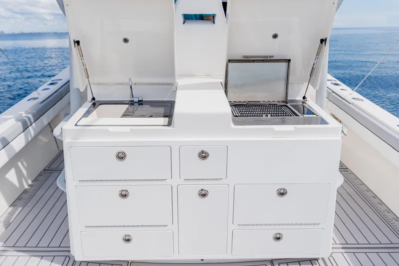 Slide: The Image of 2018 Regulator 41 boat with onboard sink and grill station, ocean backdrop. - 47