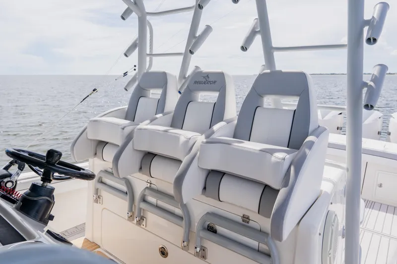 Slide: The Image of 2018 Regulator 41 boat with three cushioned seats and steering wheel, ocean view. - 55